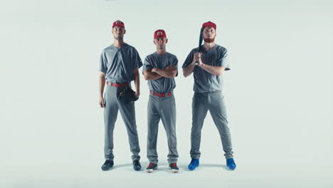 Three-Caucasian-professional-baseball-players-posing-against-white-background.-4K-UHD-60-FPS-SLOW-MOTION